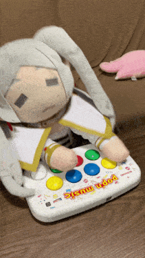 a stuffed animal is sitting on top of a konami pop n music controller