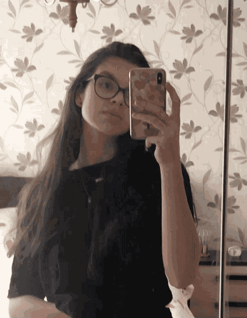 a girl taking a selfie in front of a mirror