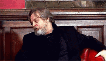 a man with a beard is sitting on a red chair