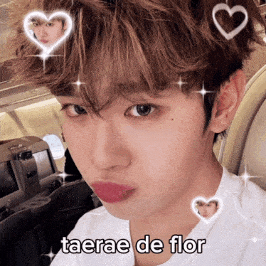 a young man with hearts around his head and the words taerae de flor written on his face