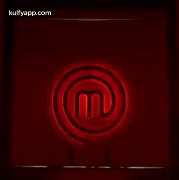 a man in a suit is walking through a doorway with a red logo on it .