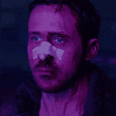 a man with a bandage on his nose is looking at something
