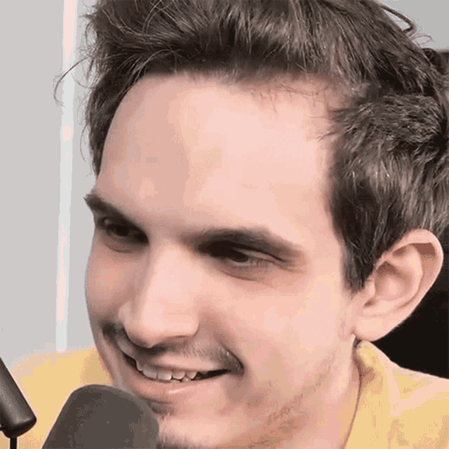 a close up of a man 's face with a microphone behind him