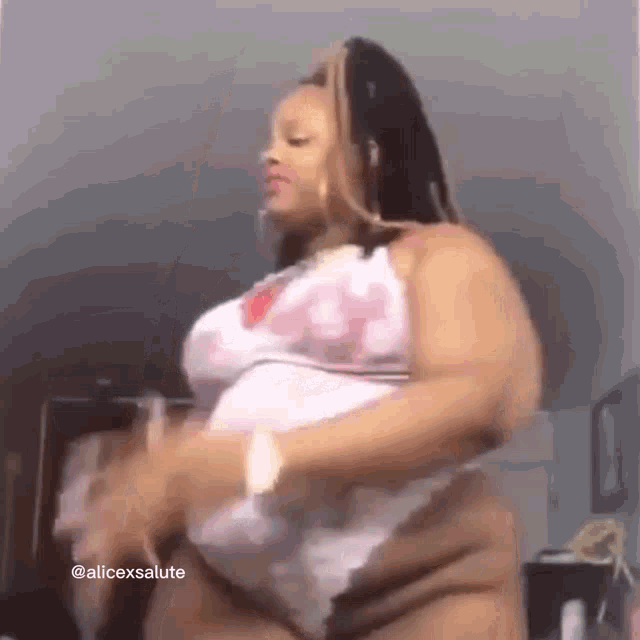 a woman in lingerie is dancing in a room while wearing a white top .
