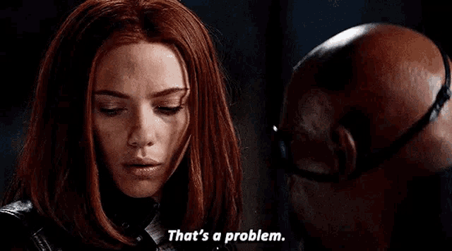 a woman with red hair is standing next to a bald man .
