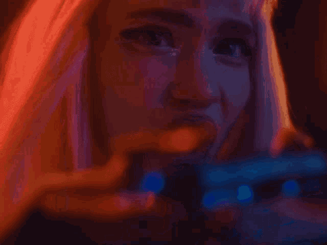 a close up of a woman 's face with pink hair
