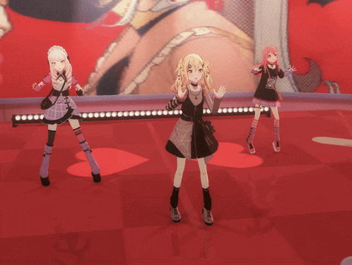three anime girls are dancing on a stage and one of them is wearing a black dress with a spider web on it