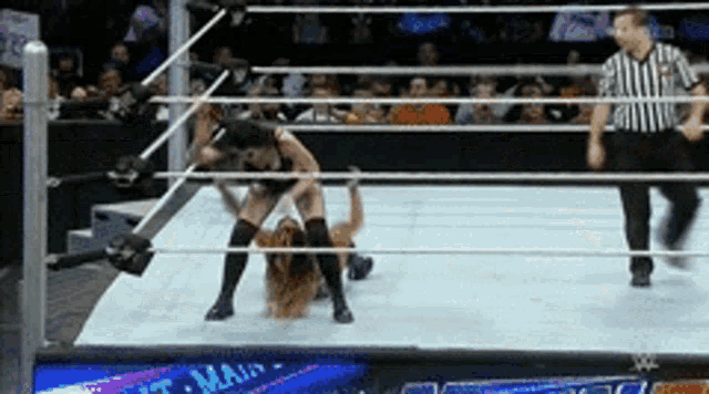 two women are wrestling in a wrestling ring with the word main on the bottom