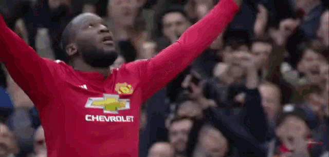 a soccer player is celebrating a goal in front of a crowd of people .