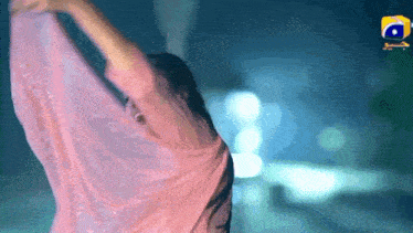 a woman in a pink dress is dancing in front of a yellow box that says ' a ' on it