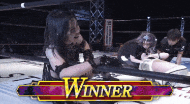 a woman in a wrestling ring with a banner that says winner on it