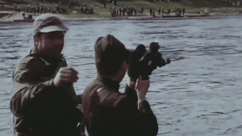 a man is holding a camera while another man looks on