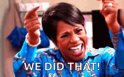 a woman in a blue shirt is screaming and pointing at the camera with the words `` we did that ! ''