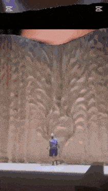 a man is standing in front of a wall that has the letters abc on it