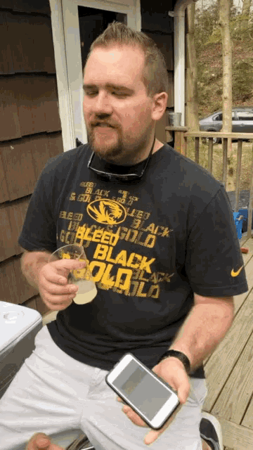 a man wearing a black shirt that says " black gold "