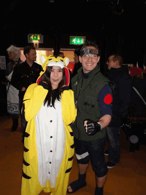 a woman in a tiger costume poses with a man in a green vest