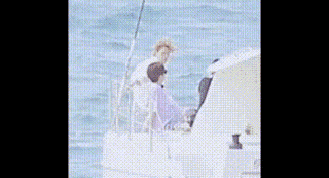 a man and a woman are on a boat in the ocean .
