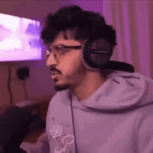 a man wearing headphones and glasses is standing in a room .
