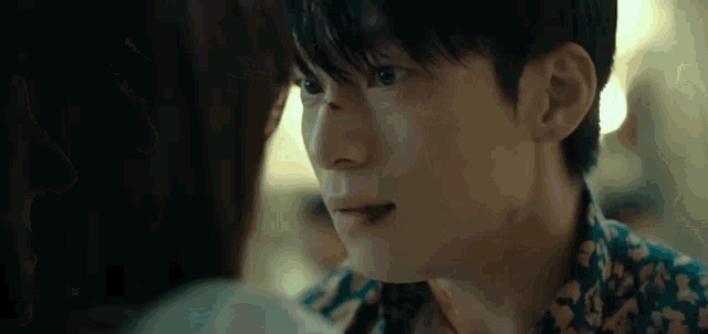 a close up of a man 's face with a woman 's face behind him .