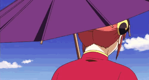 a woman in a red jacket is holding a purple umbrella over her head .