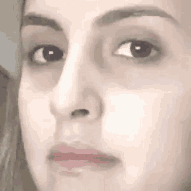 a close up of a woman 's face with her eyes closed and a slight smile on her face .
