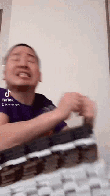 a man is making a funny face in front of a keyboard with tik tok written on the bottom