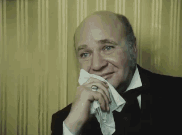 a man with a ring on his finger wipes his face