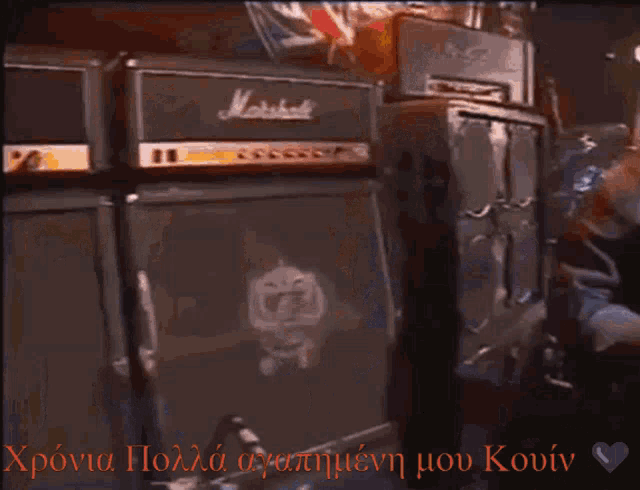 a man with long hair and a beard stands in front of a marshall amplifier