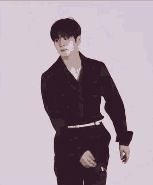 a man wearing a purple shirt and black pants with a white belt around his waist