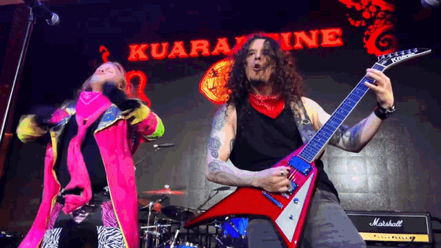 a man playing a guitar in front of a sign that says ' kuaranine '