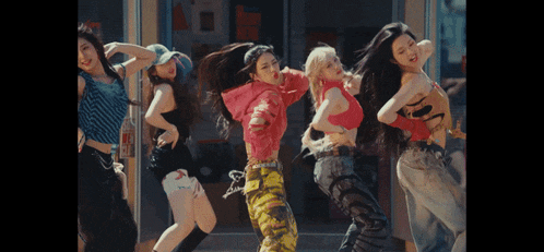 a group of young women are dancing in front of a building with a sign that says mcdonald 's