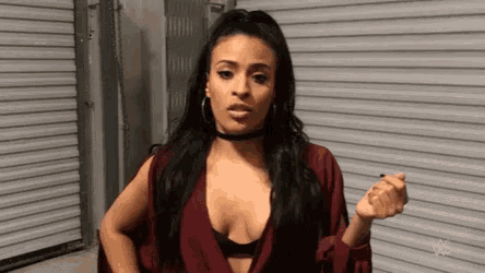 a woman in a plunging neckline and choker is standing in front of a garage door .