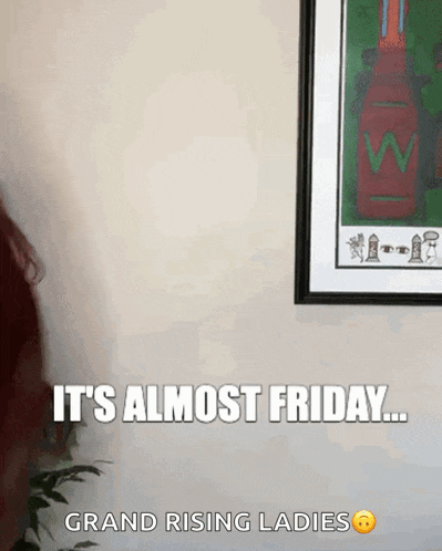a woman is standing in front of a framed picture that says " it 's almost friday "