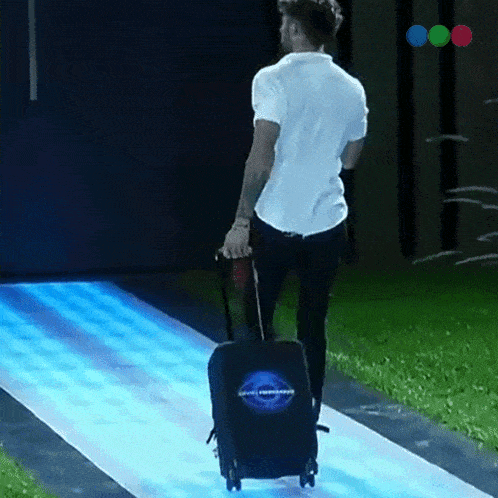 a man is pulling a suitcase that has a logo on it