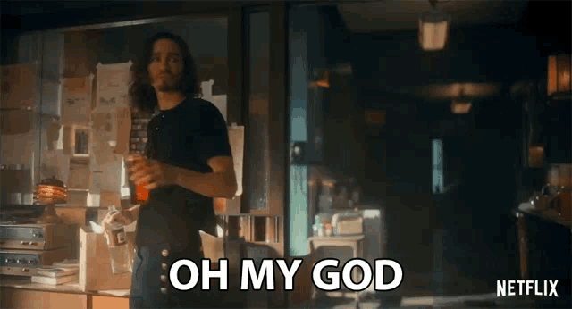 a man in a black shirt is holding a drink and saying oh my god