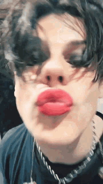 a close up of a person making a funny face with red lips .