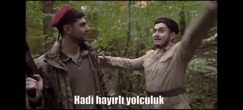 a man in a red beret stands next to another man with the words hadi hayirli yolculuk written below him