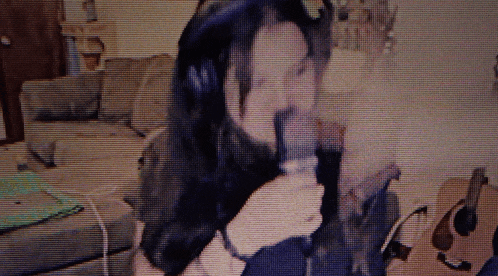 a woman wearing headphones is sitting on a couch in a living room