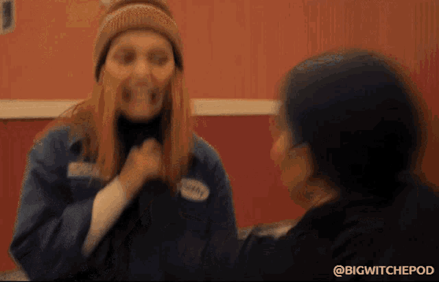 a woman in a blue jacket with a name tag that says ' wendy ' on it