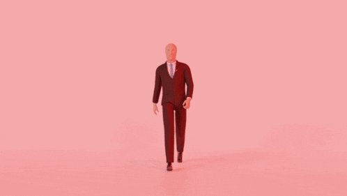 a man in a red suit and tie is standing in front of a pink background .