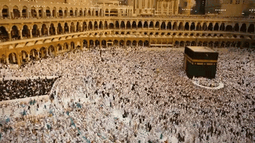 a large crowd of people are gathered in front of a mosque