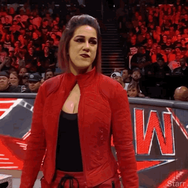 a woman in a red jacket is standing in front of a sign that says w.