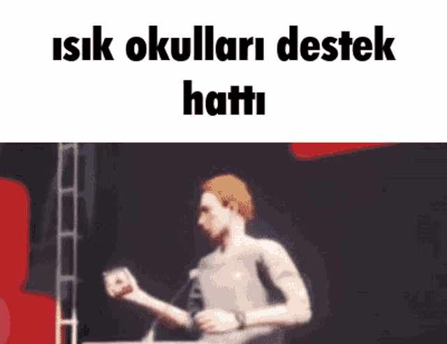 a man is dancing in front of a microphone with the words `` isik okullari destek hatti '' written on the bottom .
