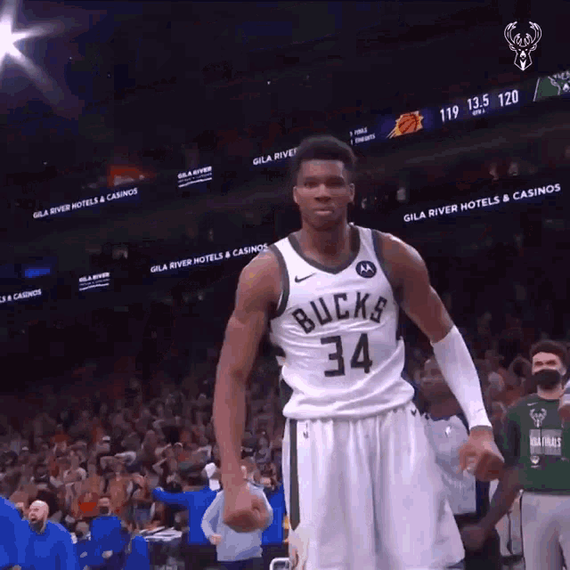 a basketball player with the number 34 on his jersey is standing in front of a crowd