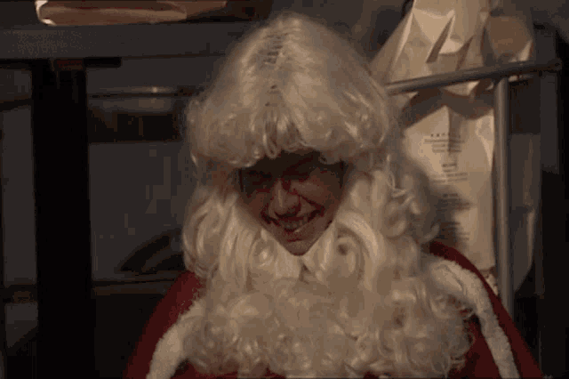 a man dressed as santa claus with a white wig on