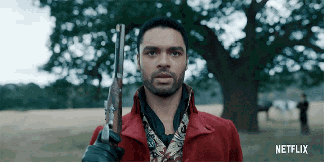 a man in a red coat is holding a gun with a netflix logo in the corner