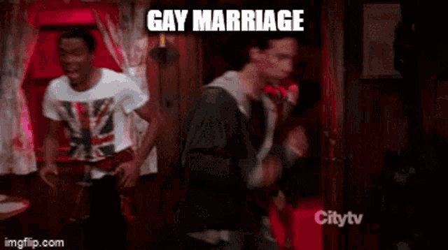 a group of people are dancing in a room with the words gay marriage written on the screen .