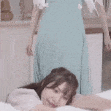 a young woman is laying on a bed with her arms outstretched and smiling .
