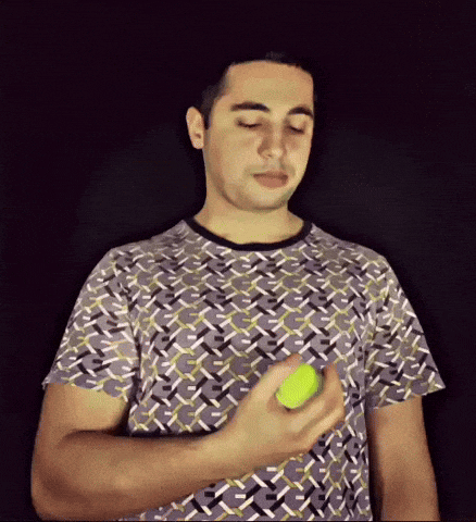 a man is holding a tennis ball in his left hand