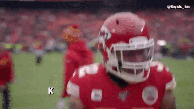 a football player wearing a red helmet with the letter k on the bottom